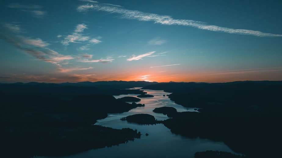 aerial photography of water beside forest during golden hour